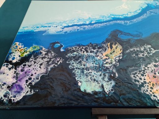 Blaue und schwarze Farbschichten mit bunten Akzenten in fluidem Muster.