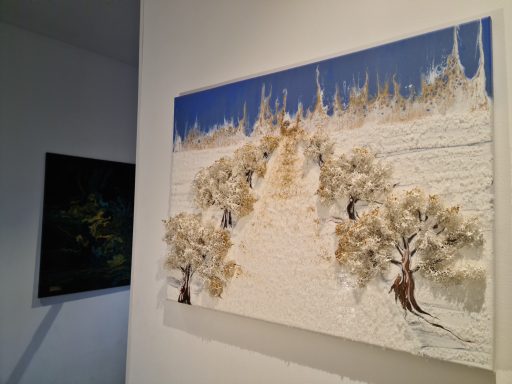 Gemälde mit einer schneebedeckten Landschaft und Bäumen unter blauem Himmel.