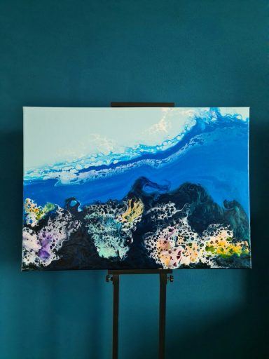 Blaue und schwarze Farbschichten mit bunten Akzenten in fluidem Muster.