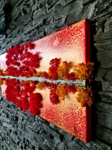 Rote und orange Blätter formen einen Baum über reflektierendes Wasser und graue Steine.