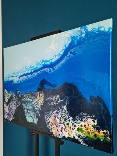 Blaue und schwarze Farbschichten mit bunten Akzenten in fluidem Muster.