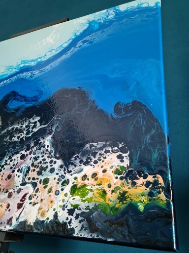 Blaue und schwarze Farbschichten mit bunten Akzenten in fluidem Muster.